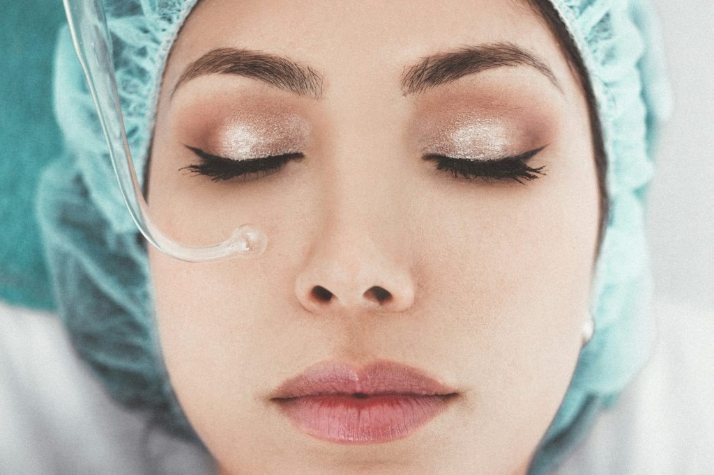 Woman undergoing facial treatment with equipment.