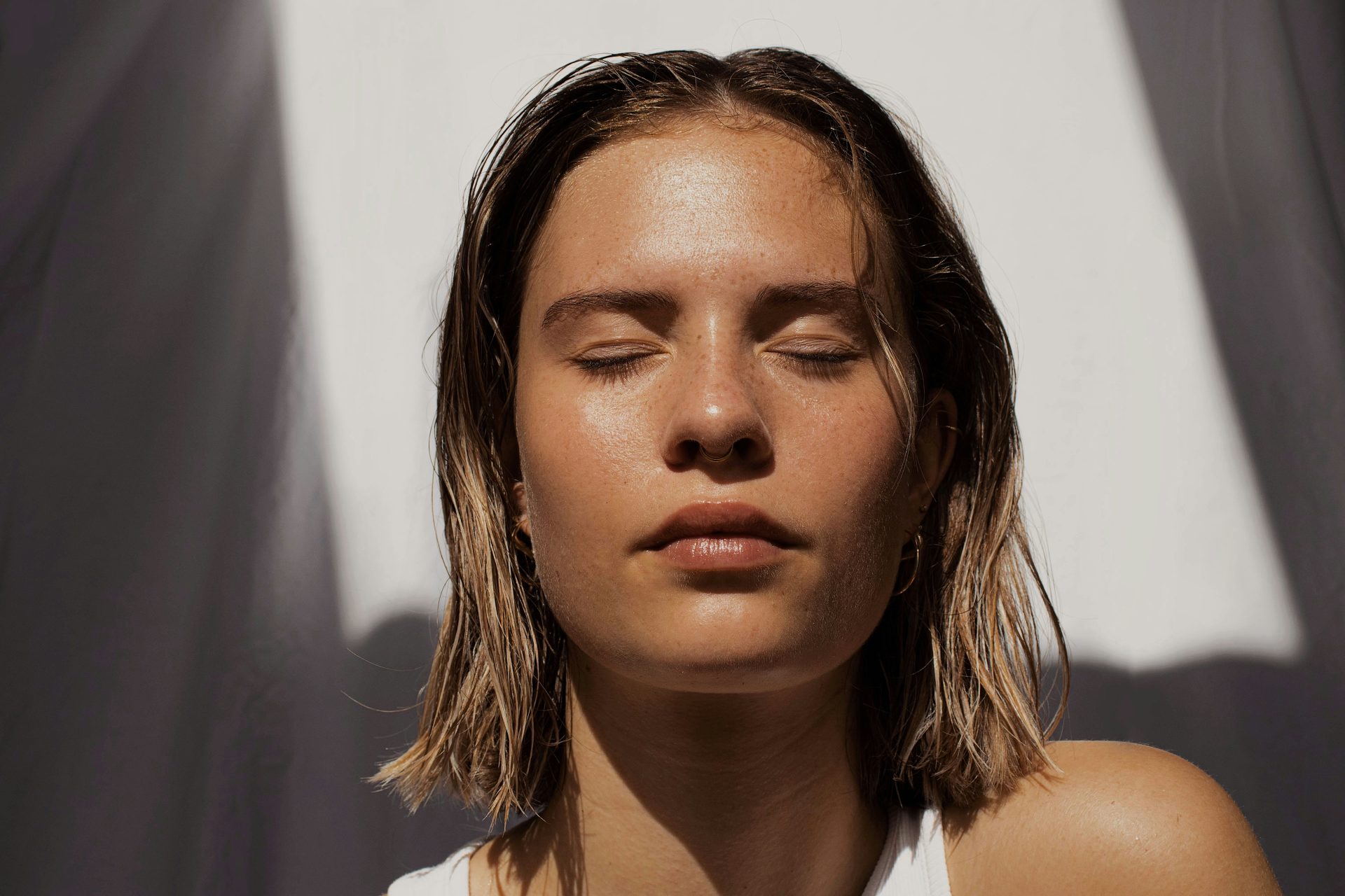 Woman basking in sunlight, eyes closed